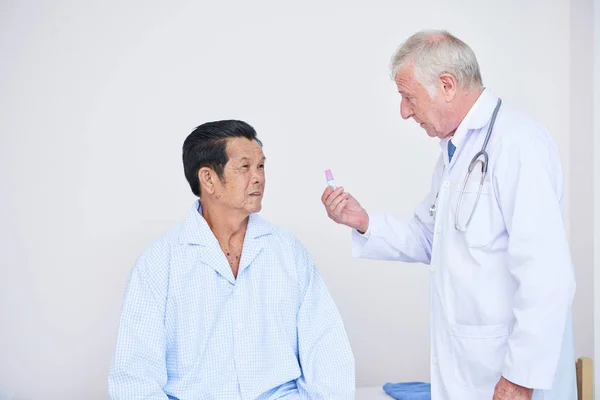 Médico Anciano Mostrando Contenedor Paciente Asiático Con Cura Mientras Visita — Foto de Stock