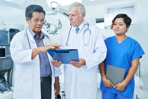 Mujer Asiática Matorrales Sosteniendo Tableta Mirando Dos Médicos Ancianos Teniendo — Foto de Stock