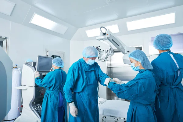 Young Surgical Assistant Helping Experienced Surgeon Put Latex Gloves Performing — Stock Photo, Image