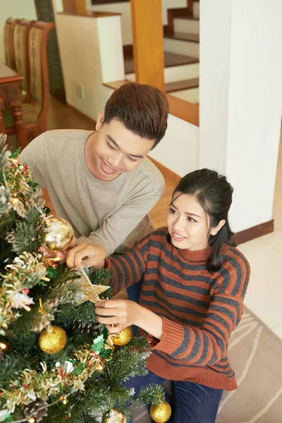 幸せな若いアジアのカップルの黄金のぶら下がって星とクリスマス ツリーにつまらない — ストック写真