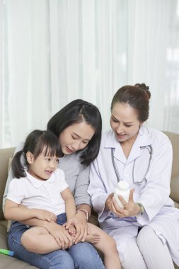 Küçük kız için vitaminler reçete olgun Vietnamlı çocuk doktoru