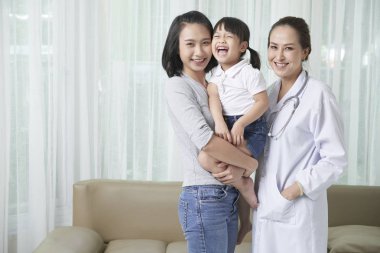 Neşeli küçük Vietnamlı kız, anne ve çocuk doktoru