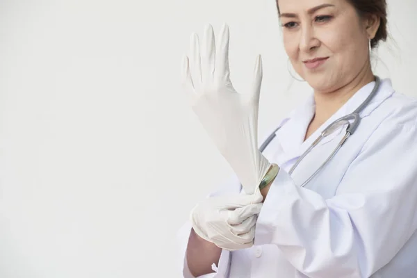 Asiatische Hausärztin Zieht Gummihandschuhe Bevor Sie Untersucht — Stockfoto