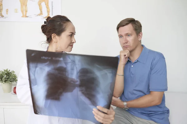Серйозний Лікар Показує Рентген Грудної Клітини Дорослому Пацієнту — стокове фото