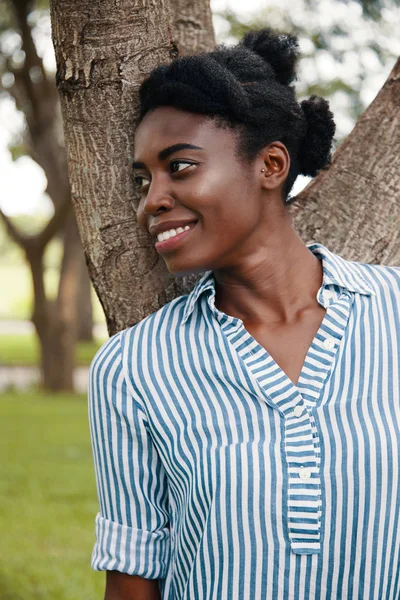 Joven Mujer Afroamericana Encantadora Con Camisa Rayas Apoyada Árbol Mirando — Foto de Stock