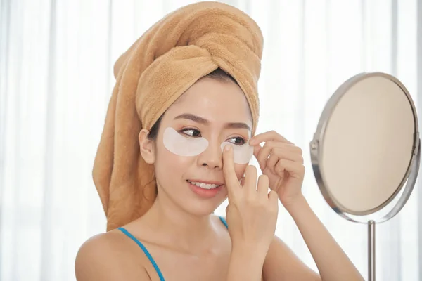 Asyalı Kadın Gözlerinin Altında Düzeltme Eklerini Uygulamayı Gülümseyen Havlu Kafa — Stok fotoğraf