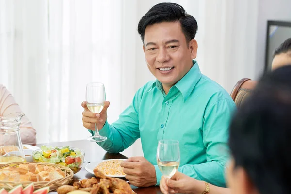 微笑的成熟亚洲男人在家庭聚餐中享用一杯葡萄酒 — 图库照片
