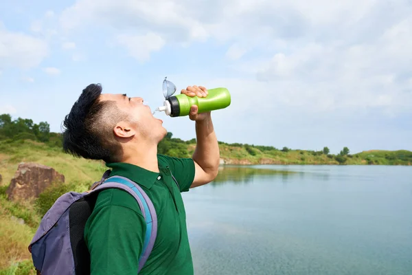 口渴的亚洲年轻人在徒步一整天后喝水 — 图库照片
