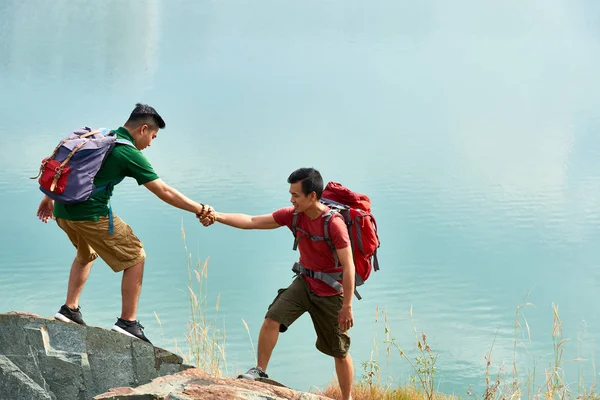 Mladí Turisté Pomáhat Navzájem Při Lezení Nahoru Horu — Stock fotografie