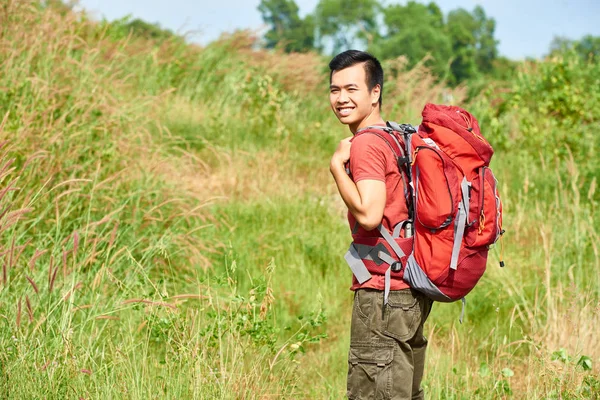 山でトレッキングの巨大なバックパックを持つ陽気な若者 — ストック写真