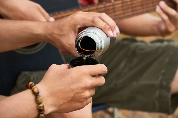 魔法瓶から熱いお茶を注ぐハイカーの手 — ストック写真