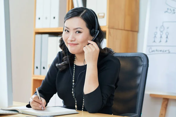 Retrato Alegre Engraçado Asiático Empresária Headset Escrever Seu Planejador — Fotografia de Stock