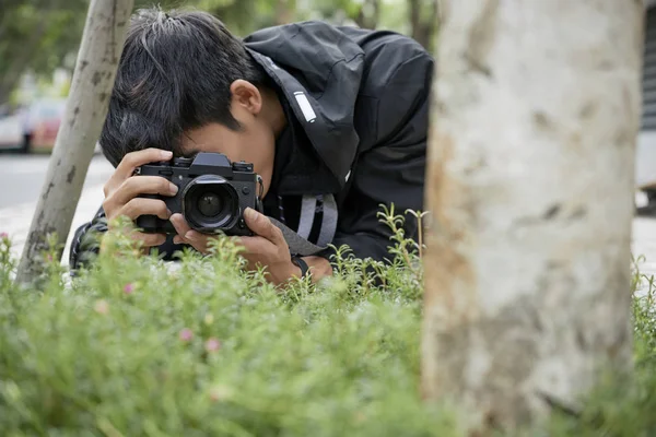 仰向けに地面と草の写真を撮る写真家 — ストック写真