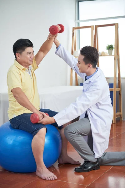 Vietnamesischer Physiotherapeut Erklärt Seniorin Wie Man Mit Hanteln Trainiert — Stockfoto