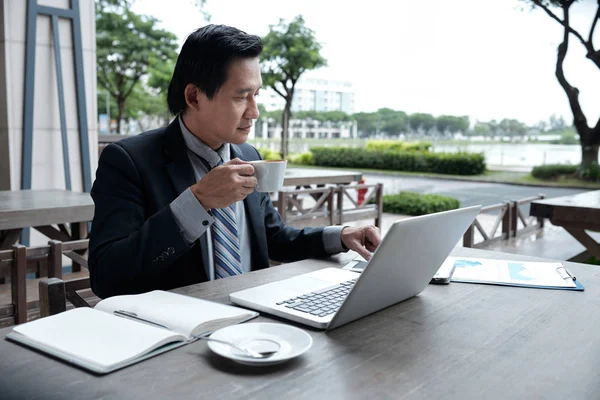 Volwassen Vietnamese Zakenman Met Koffie Het Werken Met Papieren Terras — Stockfoto