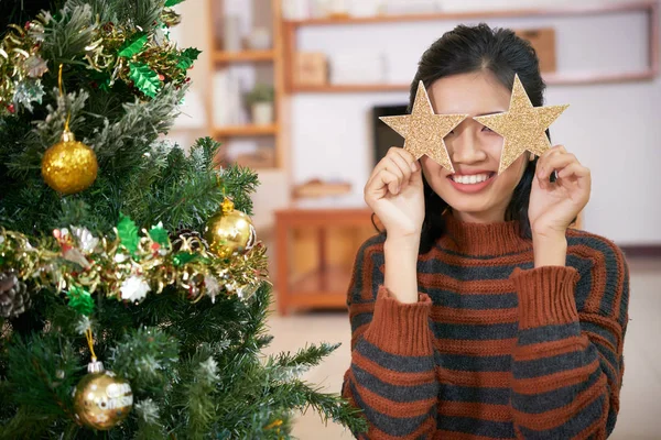 暖かいセーター輝く星と目を覆っている笑顔の若い女性 — ストック写真