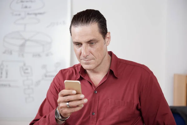 Mature Businessman Red Shirt Typing Message His Mobile Phone While — Stock Photo, Image