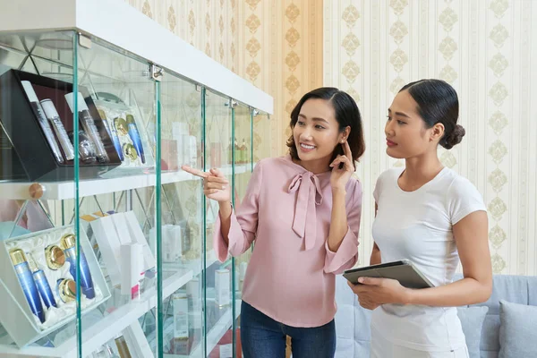 Wanita Muda Cantik Berbicara Tentang Kosmetik Rak Rak Salon Kecantikan — Stok Foto