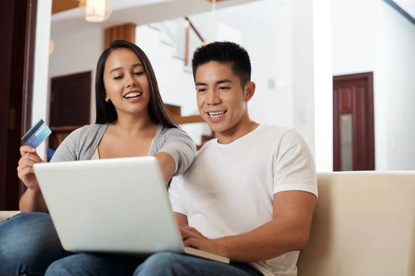 快乐的年轻混血夫妇与信用卡购物在线 — 图库照片