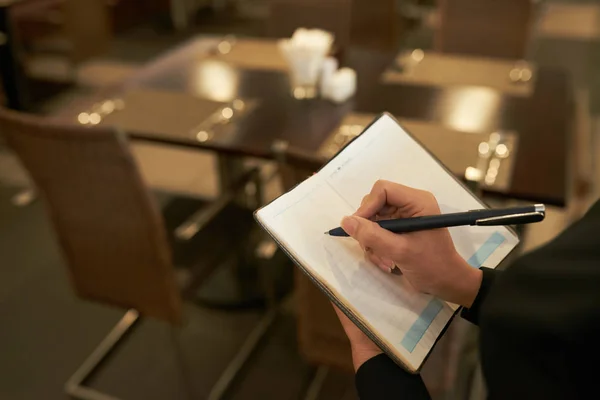 Recorte Mujer Elegante Escribiendo Bloc Notas Mientras Está Pie Restaurante — Foto de Stock