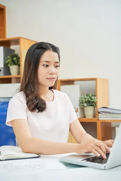 Casual Joven Mujer Asiática Escribiendo Ordenador Portátil Mientras Trabaja Oficina —  Fotos de Stock