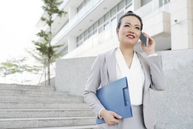 Açık havada yürüyüş ve telefonla arıyor çekici olumlu iş kadını