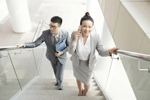 积极的亚洲企业高管走在办公楼的楼梯上 — 图库照片
