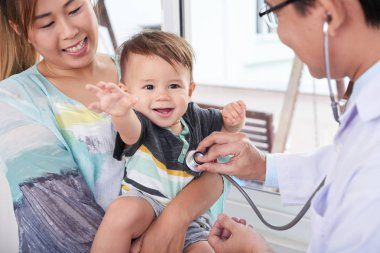 Sevimli küçük karışık ırk bebek çocuk ziyaret doktor annesiyle