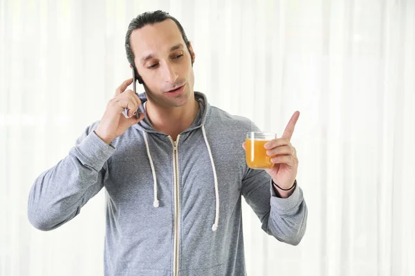 Jovem Homem Ocupado Tem Uma Conversa Seu Smartphone Beber Suco — Fotografia de Stock