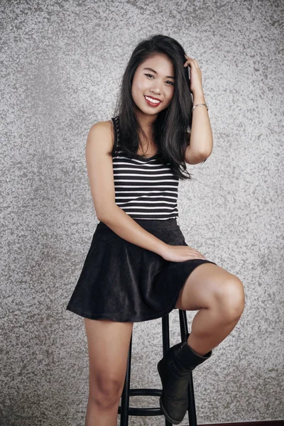 Asya Genç Modeli Sandalyede Oturan Kameraya Gülümseyen Kısa Etek Portresi — Stok fotoğraf