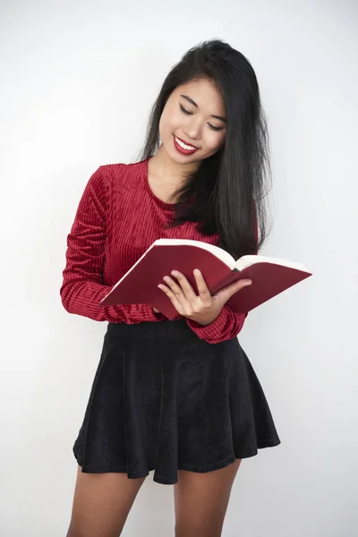 若いブルネット短い本を見てスカートは白い背景の分離 — ストック写真