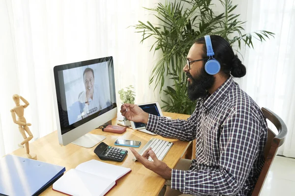 Joven Hombre Negocios Carrera Mixta Ropa Casual Auriculares Sentados Escritorio —  Fotos de Stock