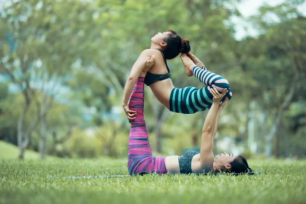 つ合わせて柔軟なアジア女性 Acroyoga 公園での練習 — ストック写真