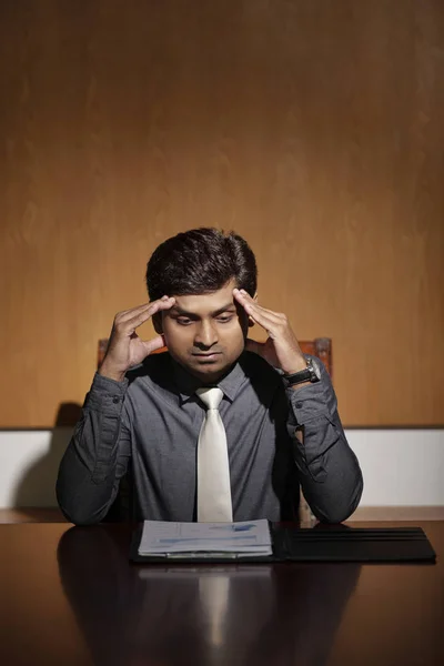 Stressed and tired Indian businessman suffering from headache