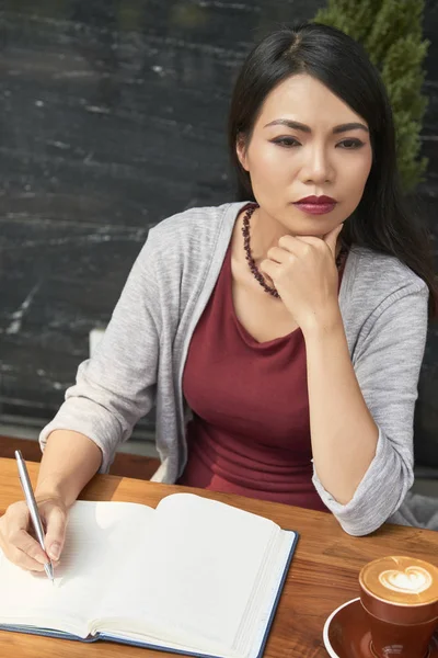 Asiatica Scrittrice Seduta Tavola Pensando Suo Nuovo Romanzo Prendendo Appunti — Foto Stock