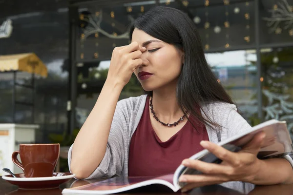 Unga Asiatiska Damen Har Huvudvärk Medan Hon Läser Tidning Och — Stockfoto