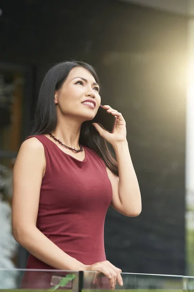 屋外で立って 携帯電話で会話中に笑顔美しいアジアの女性実業家 — ストック写真