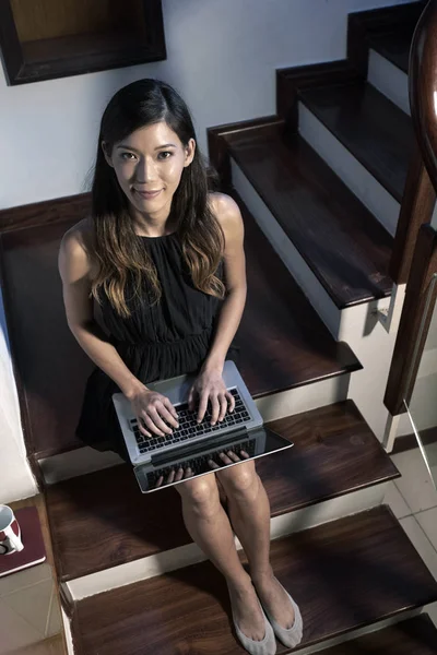 积极美丽的年轻女子坐在她的房子的台阶上 在笔记本电脑上工作 — 图库照片