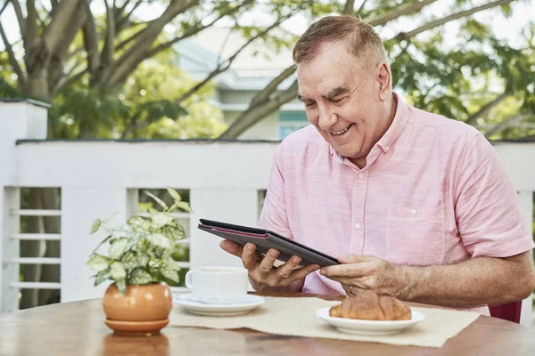 Feliz Anciano Desayunando Leyendo Noticias Tableta —  Fotos de Stock