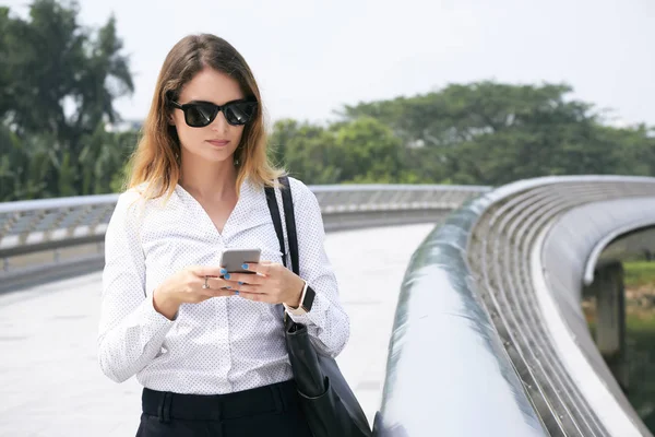 Geschäftsfrau Mit Sonnenbrille Textet Mitarbeitern Wenn Sie Draußen Steht — Stockfoto