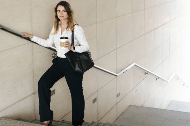 Merdivenlerde poz güzel gülümseyen İspanyol iş kadını