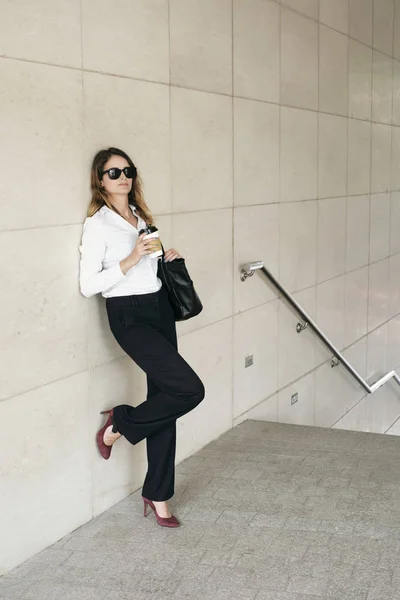 壁にもたれ 取る離れてコーヒーを飲む女性の美しいビジネス — ストック写真