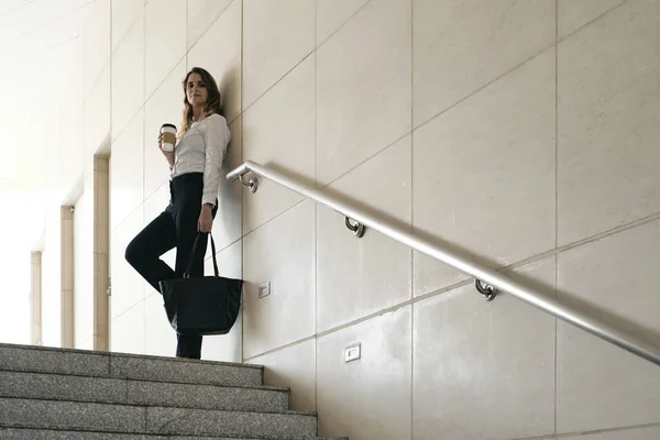 Lächelnde Hispanische Geschäftsfrau Mit Kaffeetasse Die Der Wand Lehnt Und — Stockfoto