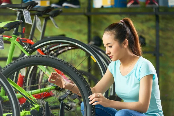 아시아 여자는가 게에서 자전거를 선택할 스포크를 — 스톡 사진