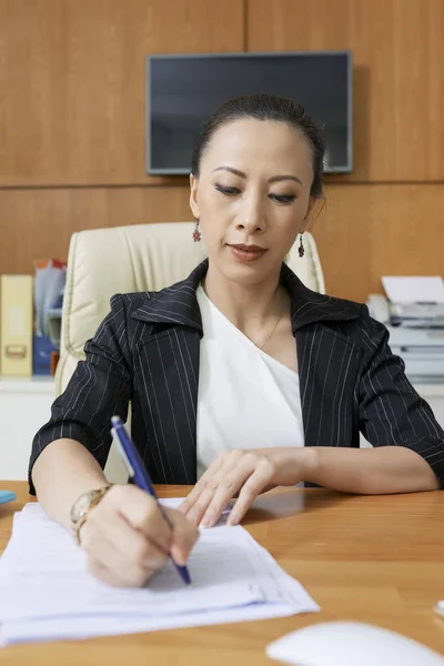 在办公室工作时 成熟的亚洲女商人填写文件 — 图库照片