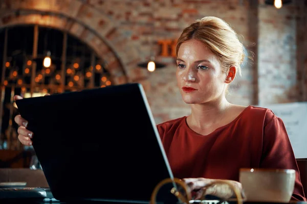 Vážné Mladá Žena Pomocí Její Laptop Pro Práci Při Posezení — Stock fotografie