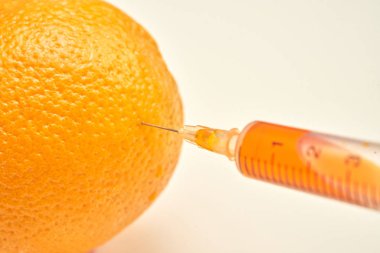 Şırınga sıvı ayıklanması ve liposuction kavramı beyaz arka plan üzerinde gösterilen parlak kabuğu ile olgun turuncu yakın çekim çekim