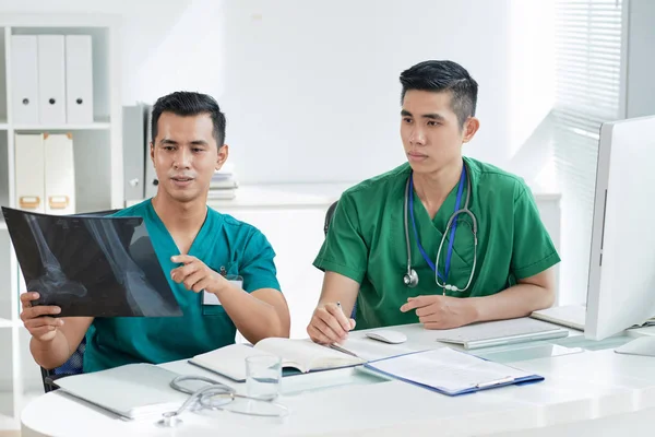 Due Uomini Asiatici Scrub Guardando Osso Foto Raggi Mentre Seduto — Foto Stock