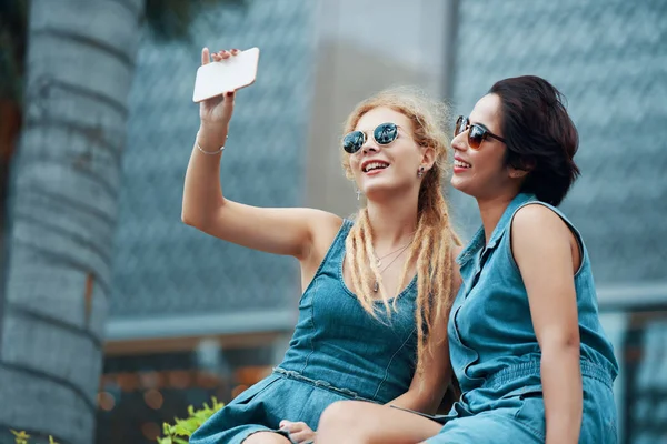 Jovens Mulheres Atraentes Óculos Sol Sentadas Tirando Selfie Com Smartphone — Fotografia de Stock