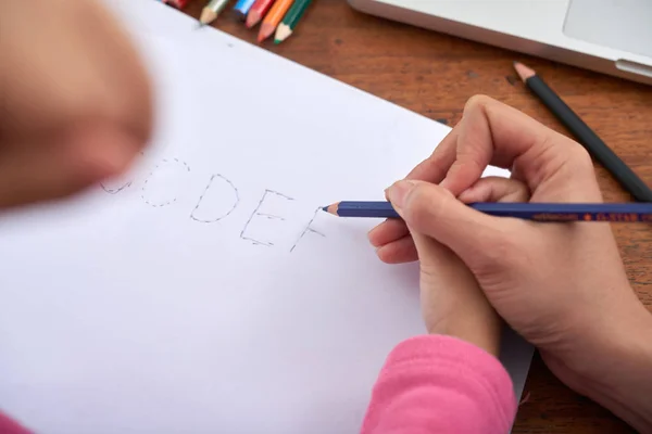 从母亲手牵着手用小女孩的手 用彩色铅笔帮助绘制字母表字母的上方拍摄的作物 — 图库照片